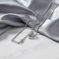 Infinity Circle Pendant Necklace on gray silk and white marble